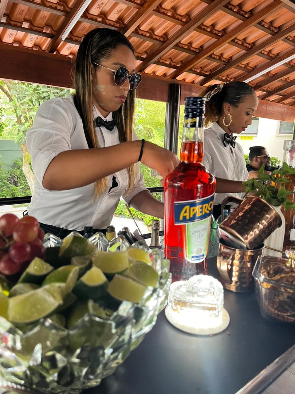 Duas bartenders de óculos trabalhando juntas em evento